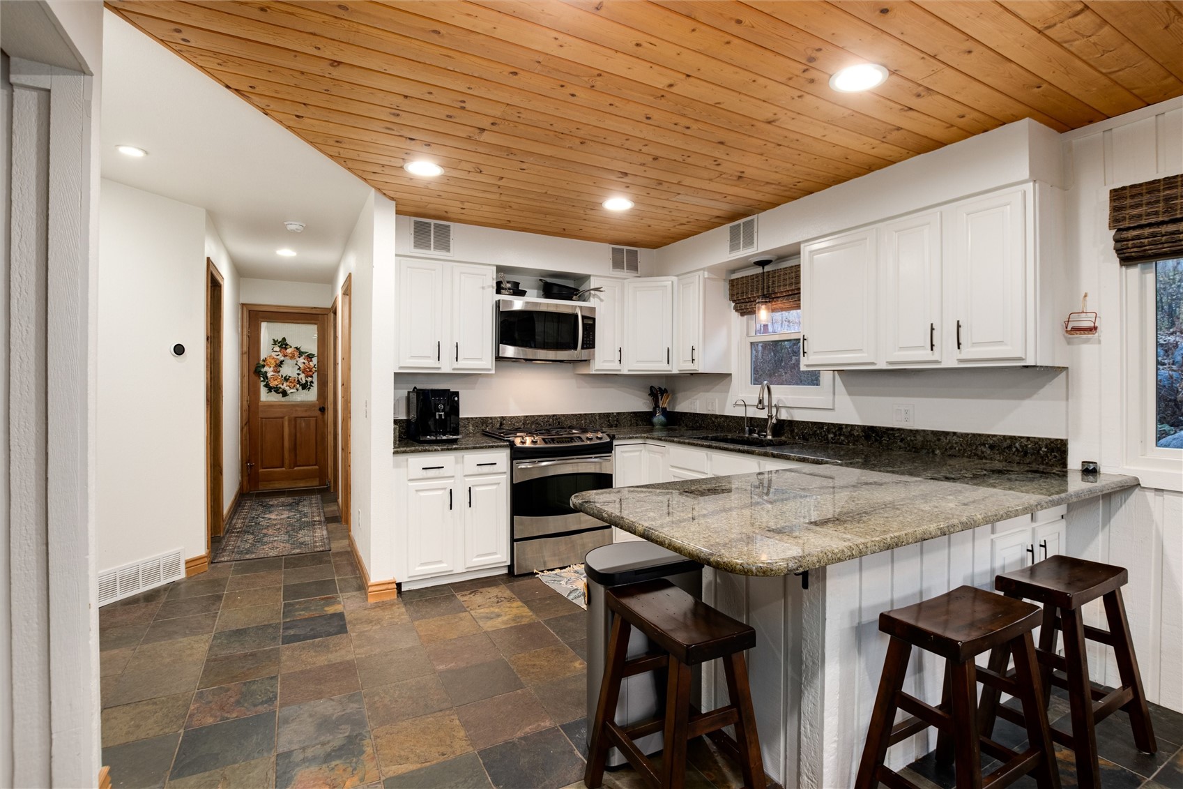384 Blue Ridge Road Breckenridge, CO 80424 - Photo 4 of 39 a kitchen with a table chairs microwave and cabinets
