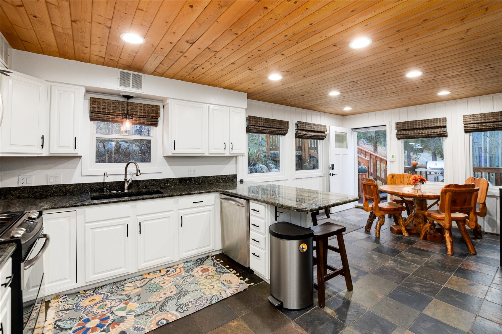 384 Blue Ridge Road Breckenridge, CO 80424 - Photo 8 of 39 a kitchen with stainless steel appliances granite countertop a table chairs sink and cabinets