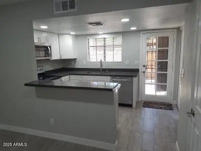a kitchen with granite countertop a stove sink and cabinets