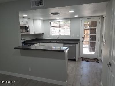 3719 East Inverness Avenue, Unit 91 Mesa, AZ 85206 - Photo 12 of 28 a kitchen with granite countertop a stove sink and cabinets