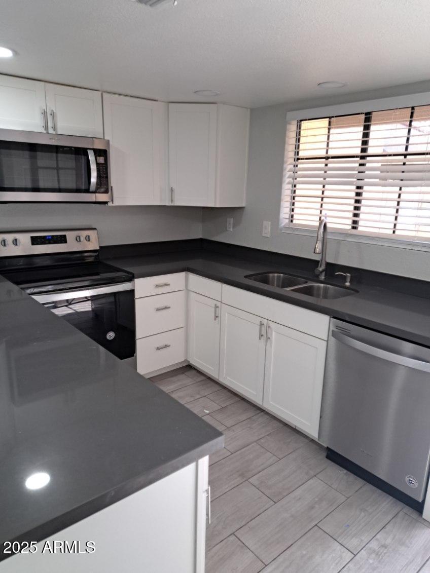 3719 East Inverness Avenue, Unit 91 Mesa, AZ 85206 - Photo 13 of 28 a kitchen with granite countertop a sink and a stove