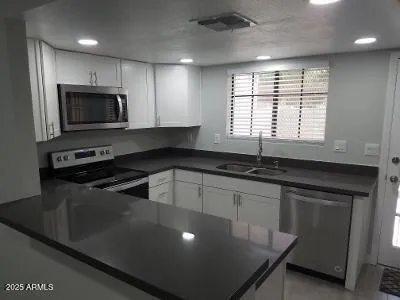 a kitchen with stainless steel appliances a sink stove and microwave