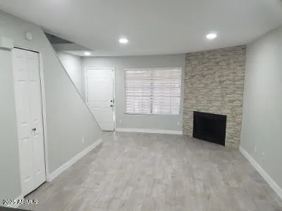 an empty room with windows and fireplace