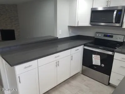 a kitchen with stainless steel appliances a stove microwave and sink