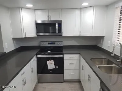 a kitchen with granite countertop a stove and a sink