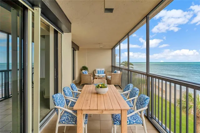 a view of a swimming pool with a lounge chair and palm trees