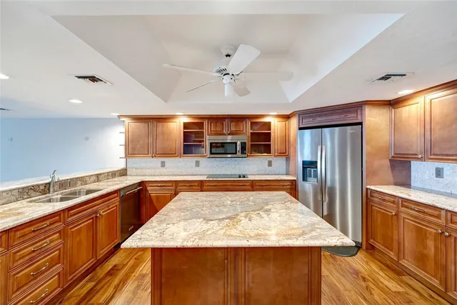a large kitchen with stainless steel appliances granite countertop a counter top and a refrigerator