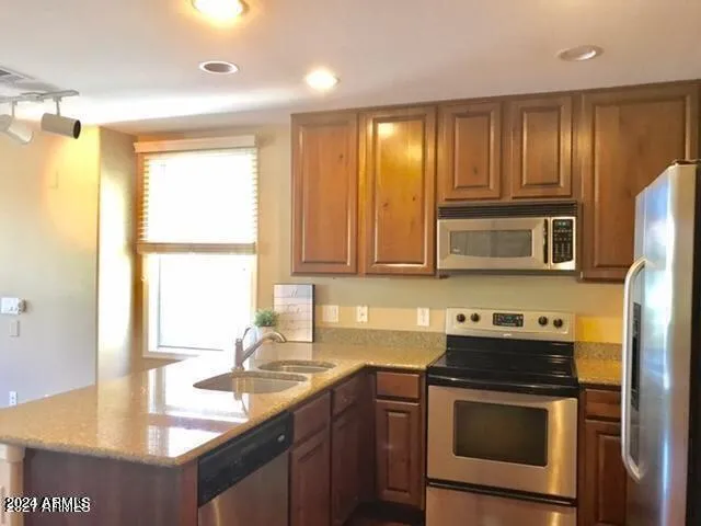 a kitchen with stainless steel appliances granite countertop a sink stove and refrigerator