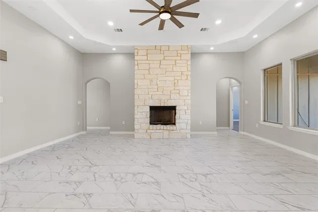 a large kitchen with stainless steel appliances a large counter top a sink and a refrigerator