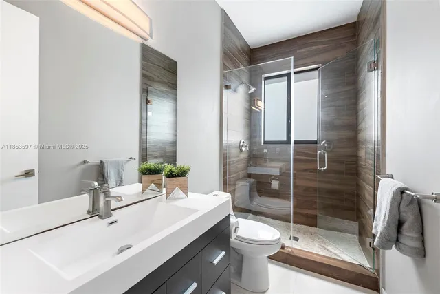 a bathroom with a bathtub shower sink vanity and toilet