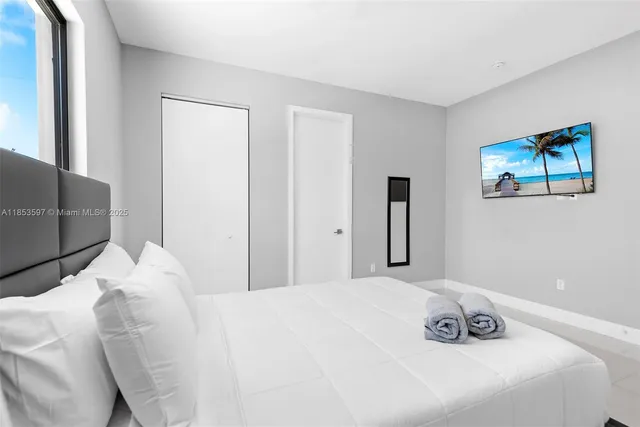 a bedroom with a bed and a white wall