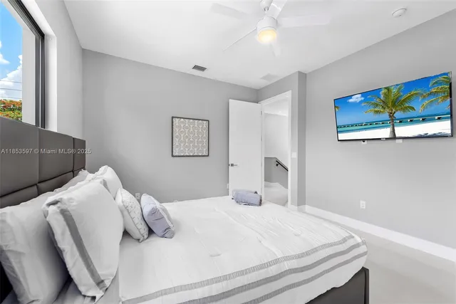 a large kitchen with stainless steel appliances granite countertop a sink dishwasher a stove a refrigerator a dining table and chairs with wooden floor