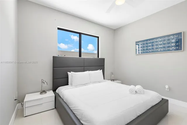 a view of yellow house with a yard and potted plants