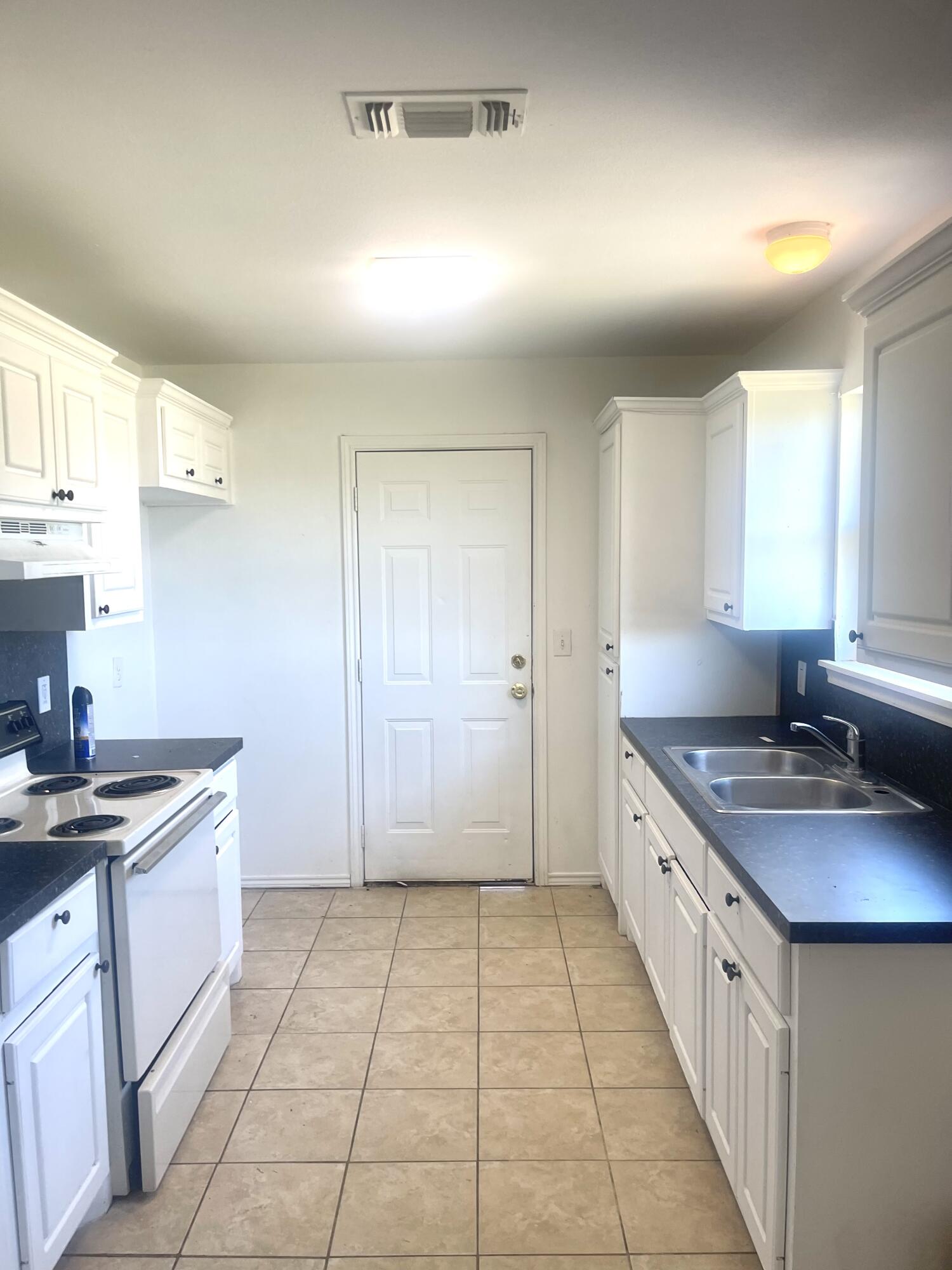 602 43rd Street Lubbock, TX 79404 - Photo 5 of 8 a kitchen with a sink stove and cabinets