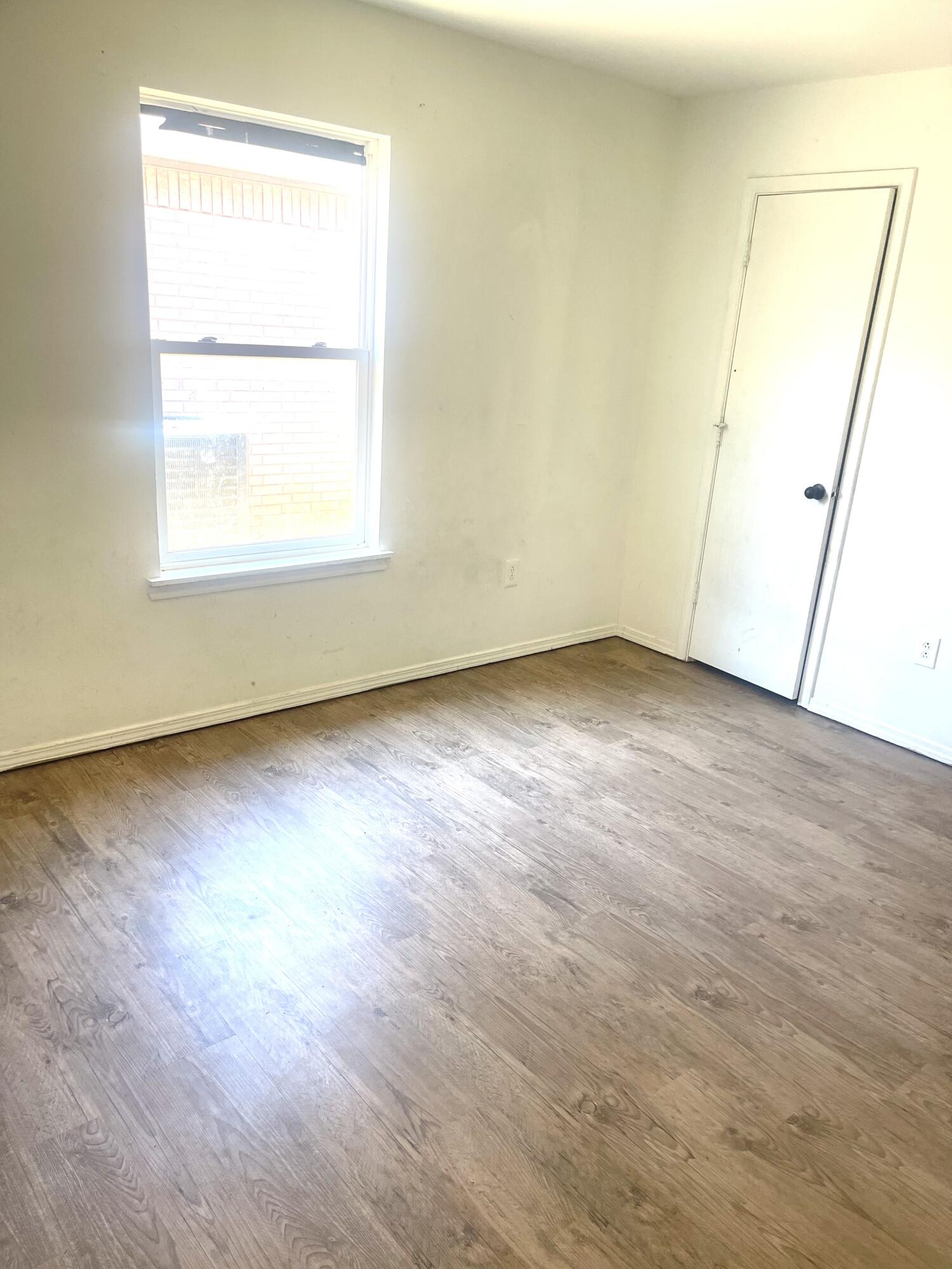 602 43rd Street Lubbock, TX 79404 - Photo 6 of 8 an empty room with wooden floor and windows