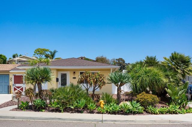 a front view of a house with plants