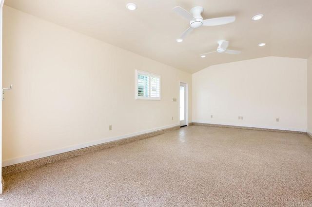 an empty room with a ceiling fan and window