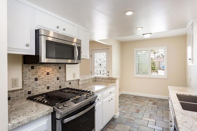 a kitchen with granite countertop a stove and a sink
