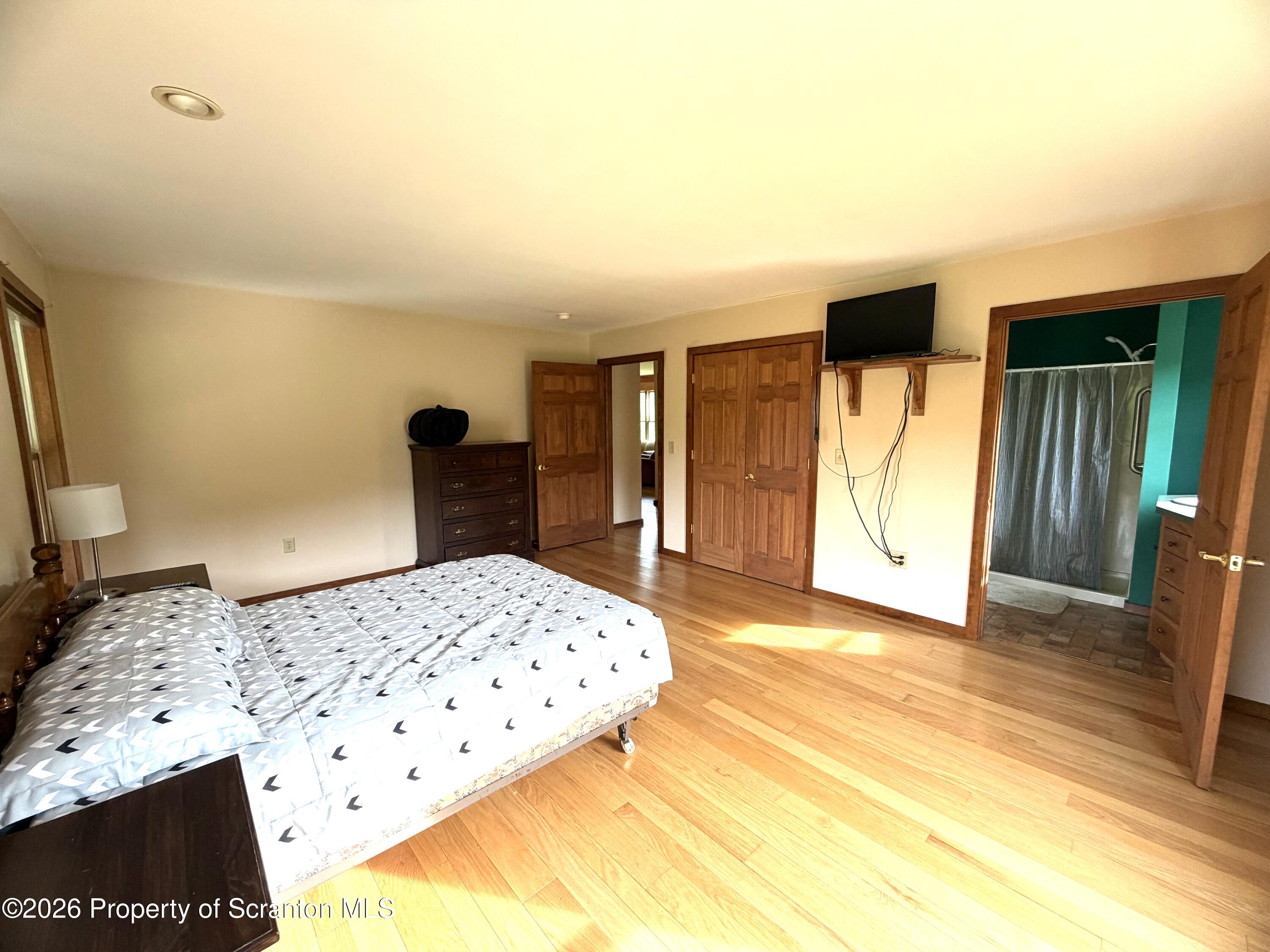 5290 Irish Hill Road Montrose, PA 18801 - Photo 34 of 67 a bedroom with a bed and a flat tv screen on dresser