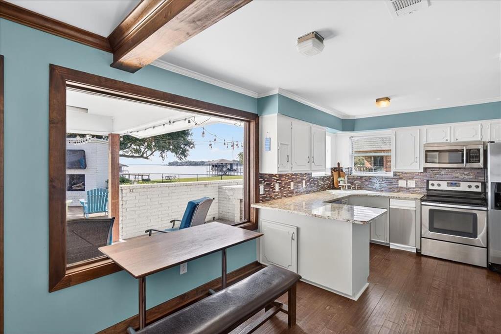 114 Baker B Ranch Road Trinidad, TX 75163 - Photo 11 of 25 a kitchen with a stove a sink dishwasher a refrigerator with white cabinets and wooden floor