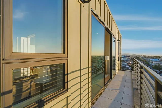 a view of a balcony with floor to ceiling windows with wooden floor