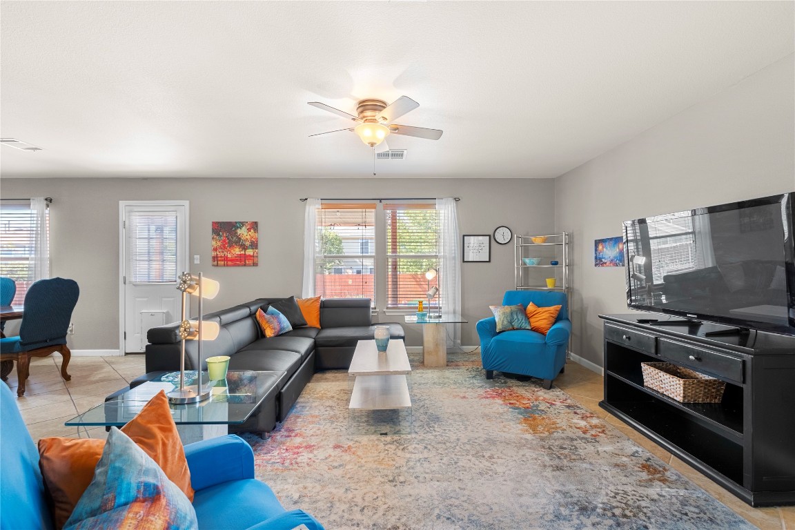 a living room with furniture a flat screen tv and a window