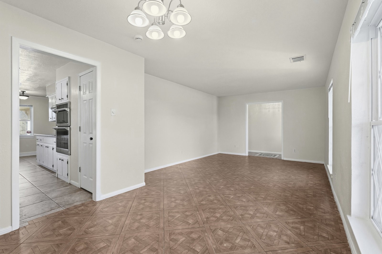 2518 Henderson Lane Deer Park, TX 77536 - Photo 7 of 28 en empty room with kitchen view and wooden floor