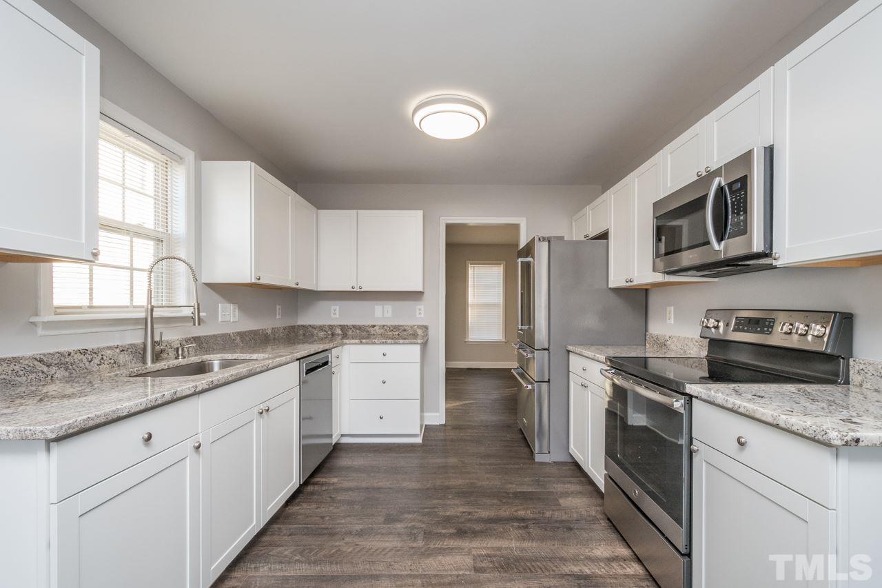 4312 Windlass Court Raleigh, NC 27616 - Photo 4 of 22 a kitchen with a sink stove oven and cabinets