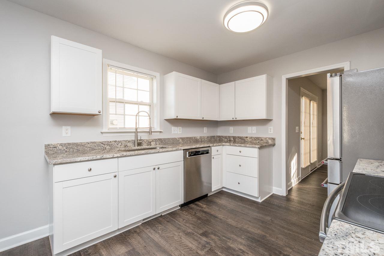 4312 Windlass Court Raleigh, NC 27616 - Photo 5 of 22 a kitchen with granite countertop a sink cabinets and wooden floor