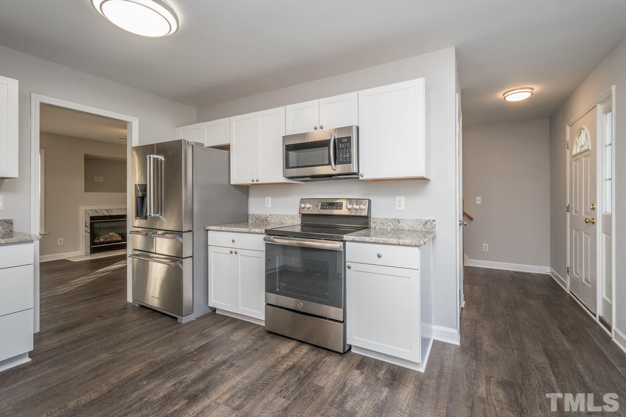 4312 Windlass Court Raleigh, NC 27616 - Photo 6 of 22 a kitchen with a refrigerator stove and wooden cabinets