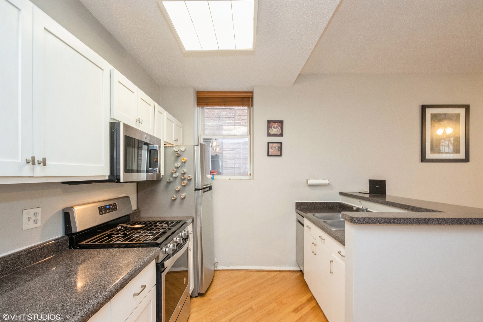 647 West Sheridan Road, Unit 1E Chicago, IL 60613 - Photo 11 of 17 a kitchen with granite countertop a sink stove and cabinets