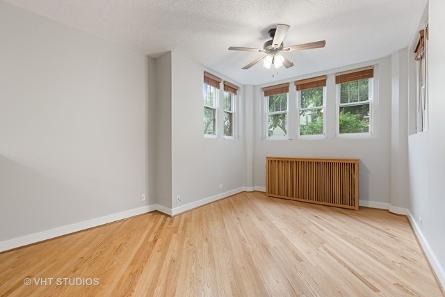647 West Sheridan Road, Unit 1E Chicago, IL 60613 - Photo 4 of 17 an empty room with wooden floor and windows