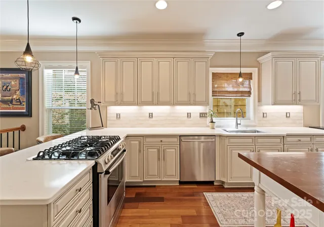 a kitchen with stainless steel appliances granite countertop a sink stove and cabinets