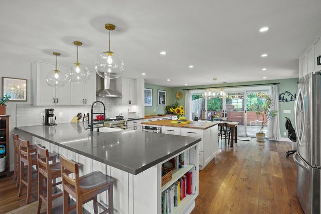 a kitchen with a table chairs stove and wooden floor