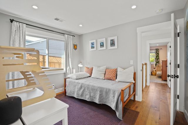 a spacious bedroom with a bed and wooden floor