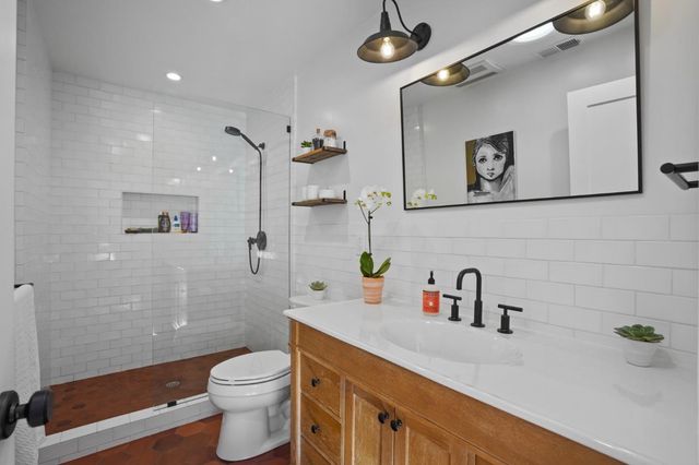 a bathroom with a sink a toilet and shower