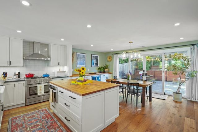 a open kitchen with stainless steel appliances granite countertop a stove and wooden floor