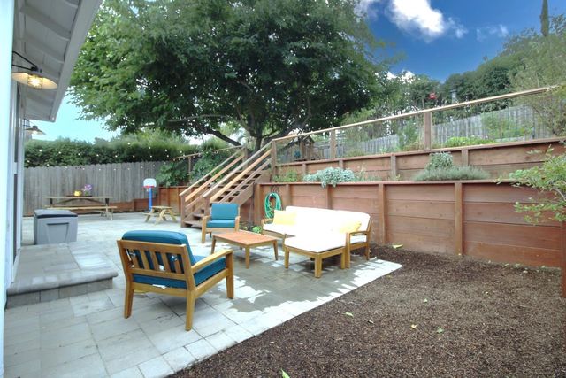a view of a fountain in the yard with wooden fence