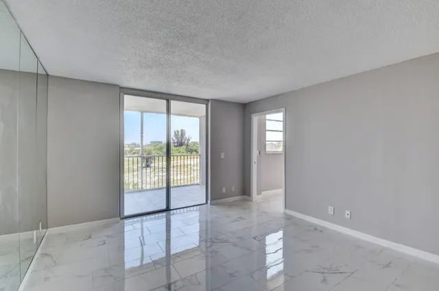 a view of an empty room with window and bathroom