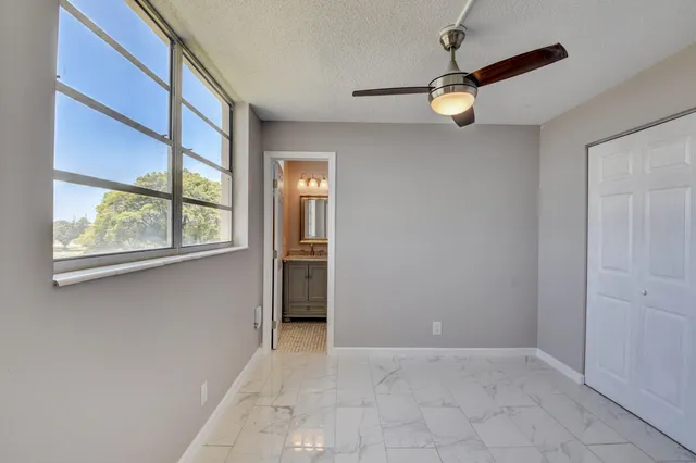 a view of a livingroom with a ceiling fan and window