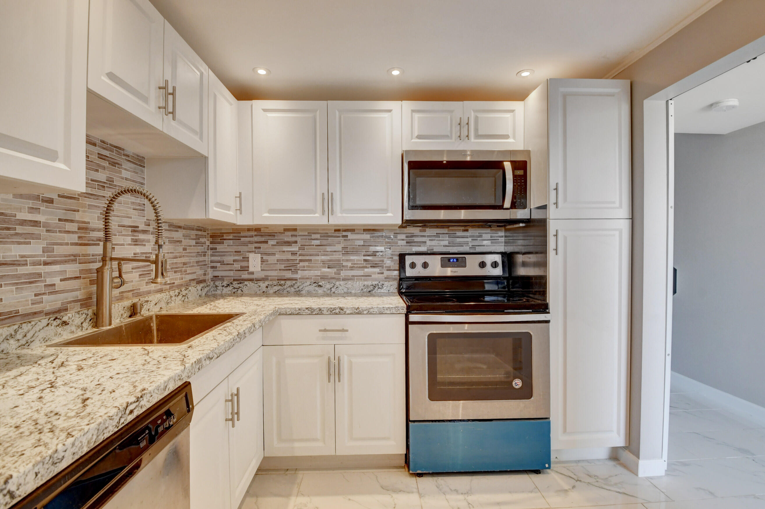 5500 Northwest 2nd Avenue, Unit 418 Boca Raton, FL 33487 - Photo 31 of 43 a kitchen with stainless steel appliances granite countertop a stove microwave and sink