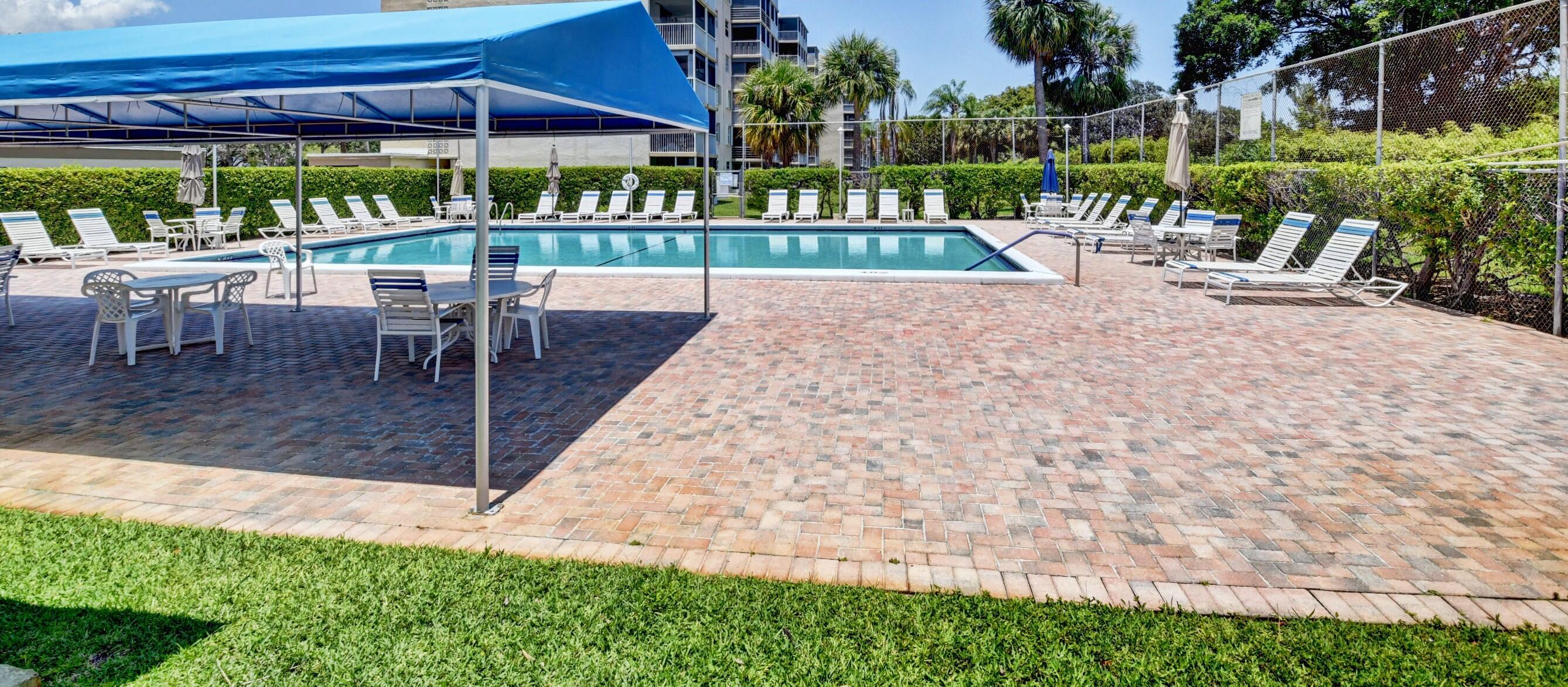 5500 Northwest 2nd Avenue, Unit 418 Boca Raton, FL 33487 - Photo 33 of 43 a view of a chairs and table in patio with a yard