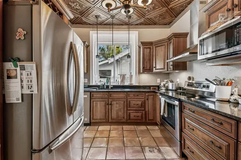 a kitchen with stainless steel appliances granite countertop a refrigerator and a stove top oven