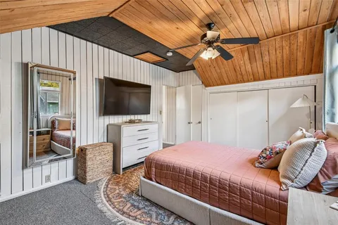 a bedroom with a bed and a flat tv screen on dresser