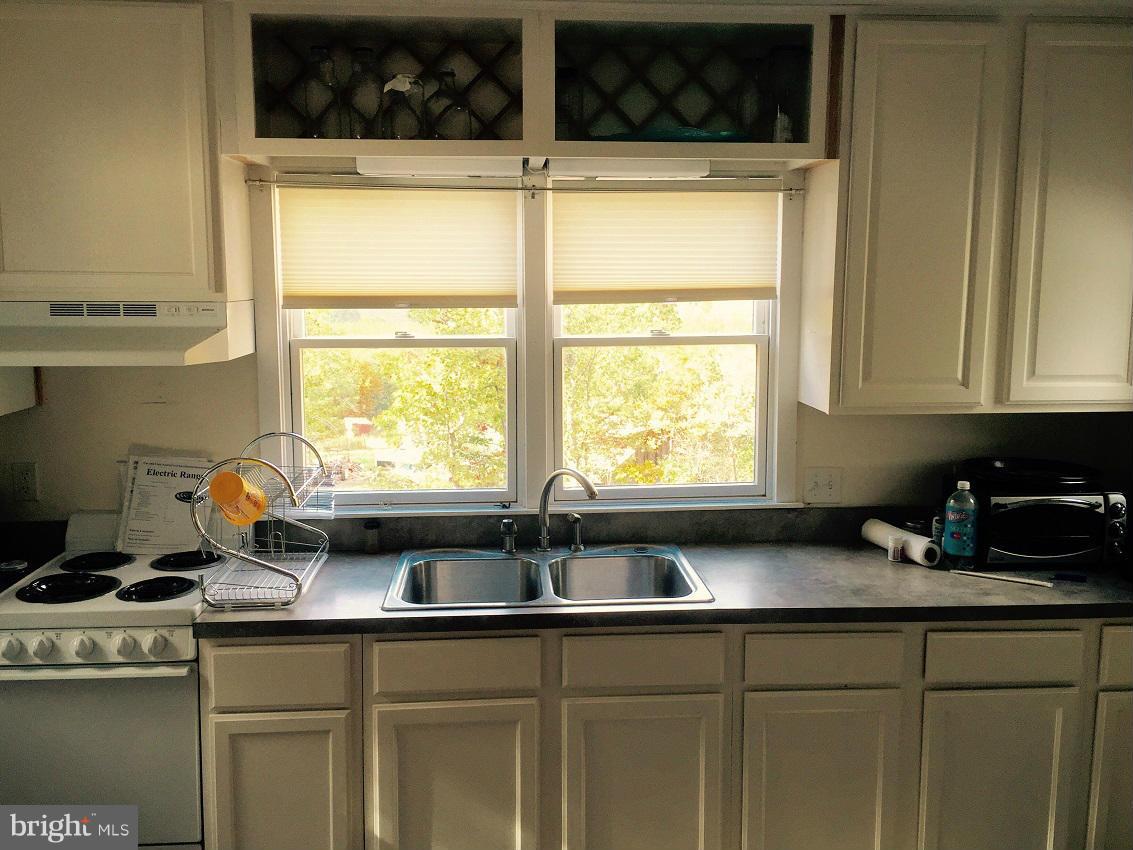 1044 Spielman Road Berkeley Springs, WV 25411 - Photo 24 of 25 a kitchen with a sink a window and cabinets