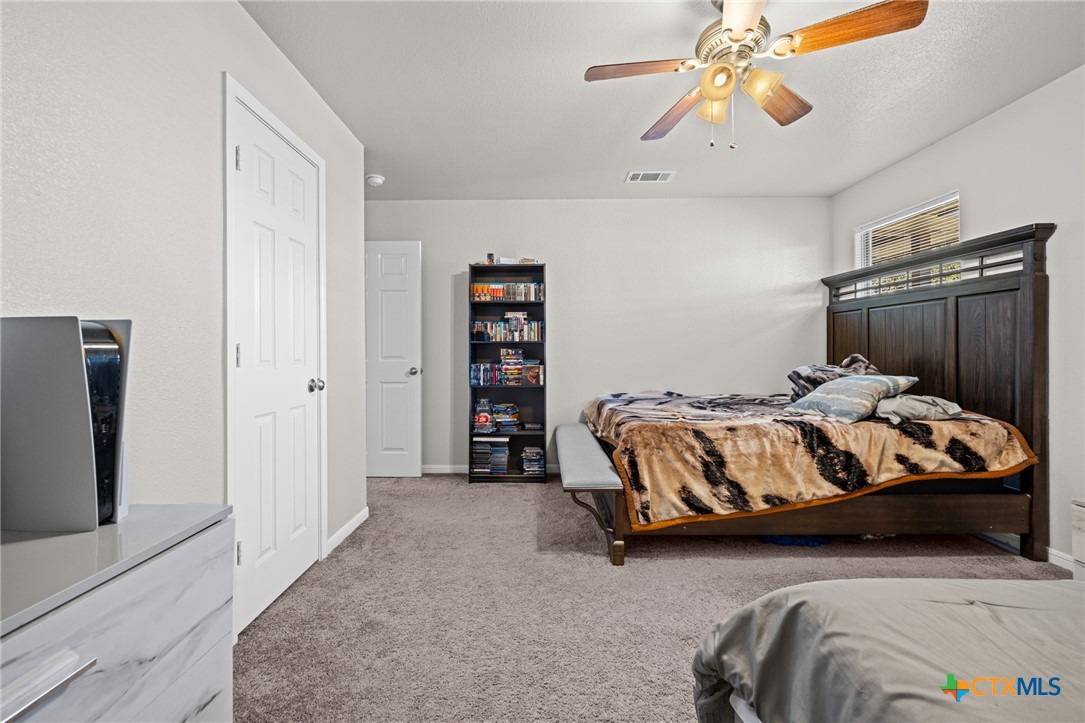 4712 Ramhorn Killeen, TX 76542 - Photo 23 of 27 a bedroom with a bed and a chandelier