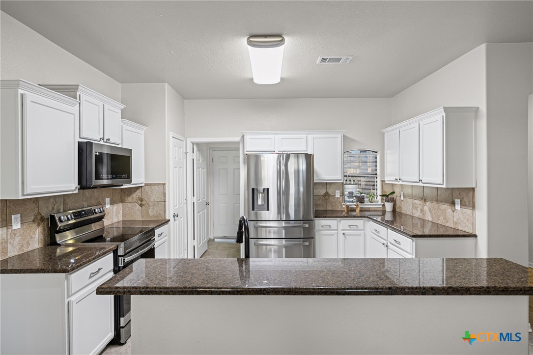 4712 Ramhorn Killeen, TX 76542 - Photo 10 of 27 a kitchen with kitchen island granite countertop a sink and refrigerator