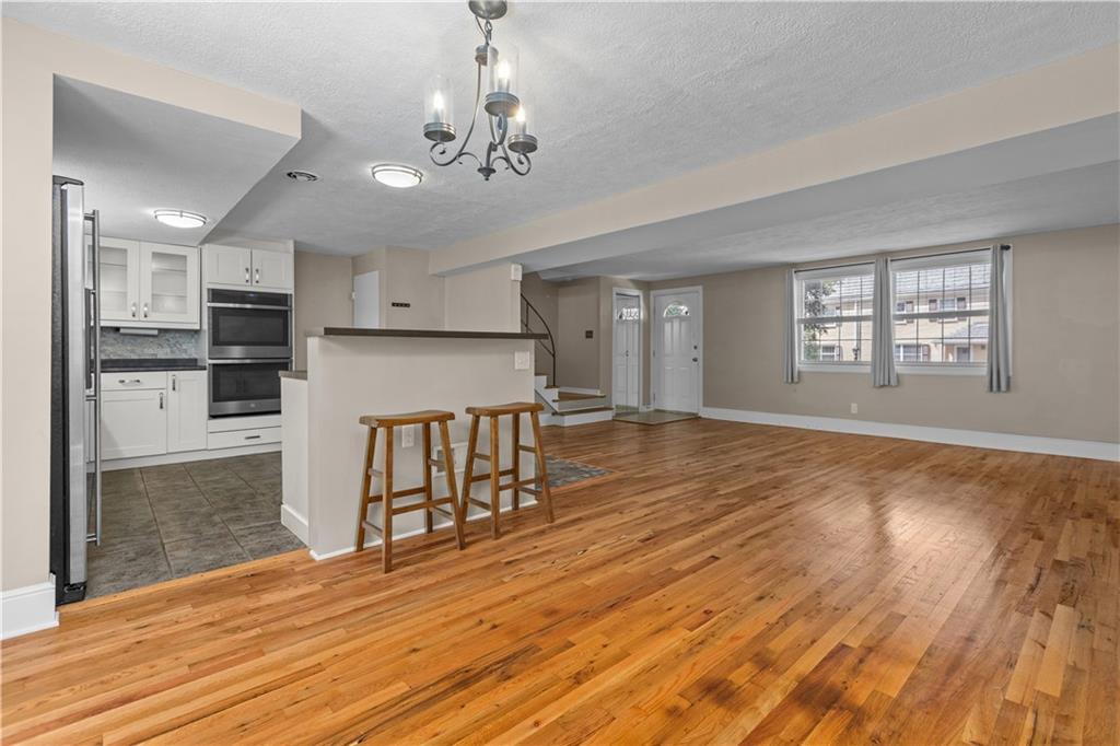 109 Raleigh Court Pittsburgh, PA 15237 - Photo 10 of 21 a view of an empty room with wooden floor and a kitchen