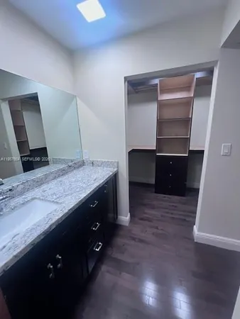 a bathroom with a granite countertop sink and a mirror