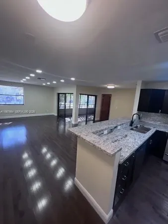a open kitchen with kitchen island a sink dishwasher stove with wooden floor